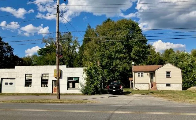 a view of a white building next to a yard