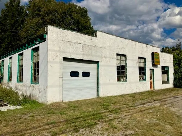a view of house with yard and tree in front of it