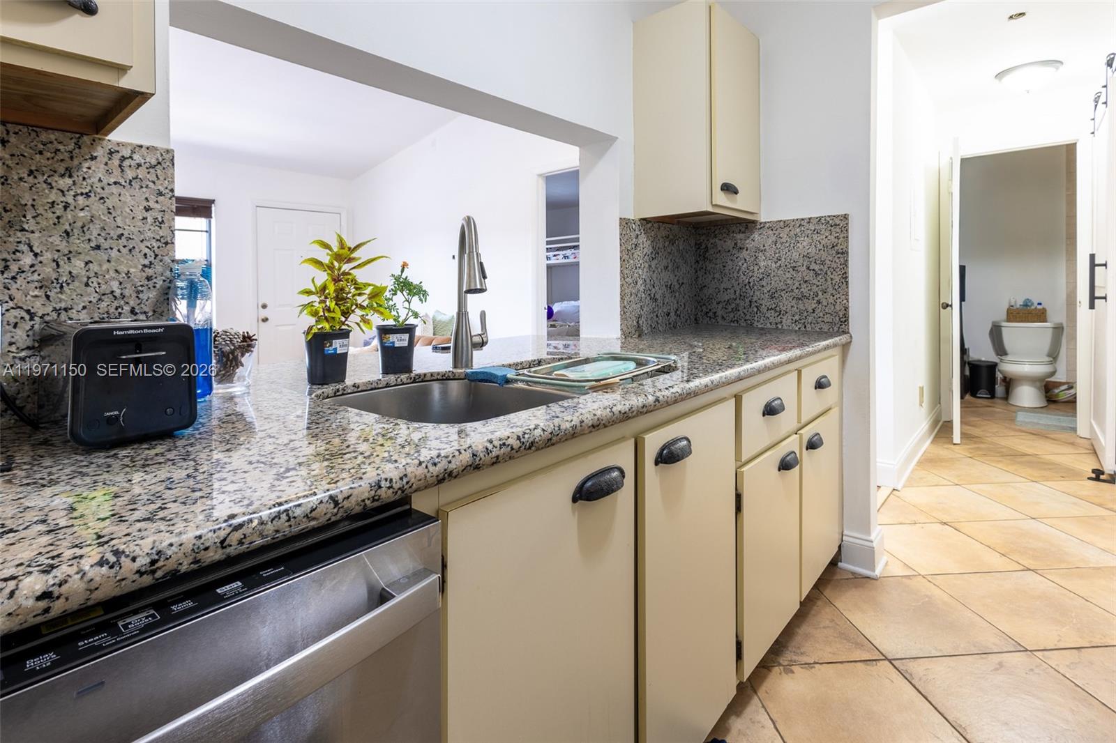 9430 Boca Cove Circle, Unit 210 Boca Raton, FL 33428 - Photo 12 of 24 a kitchen with granite countertop a sink a stove and cabinets