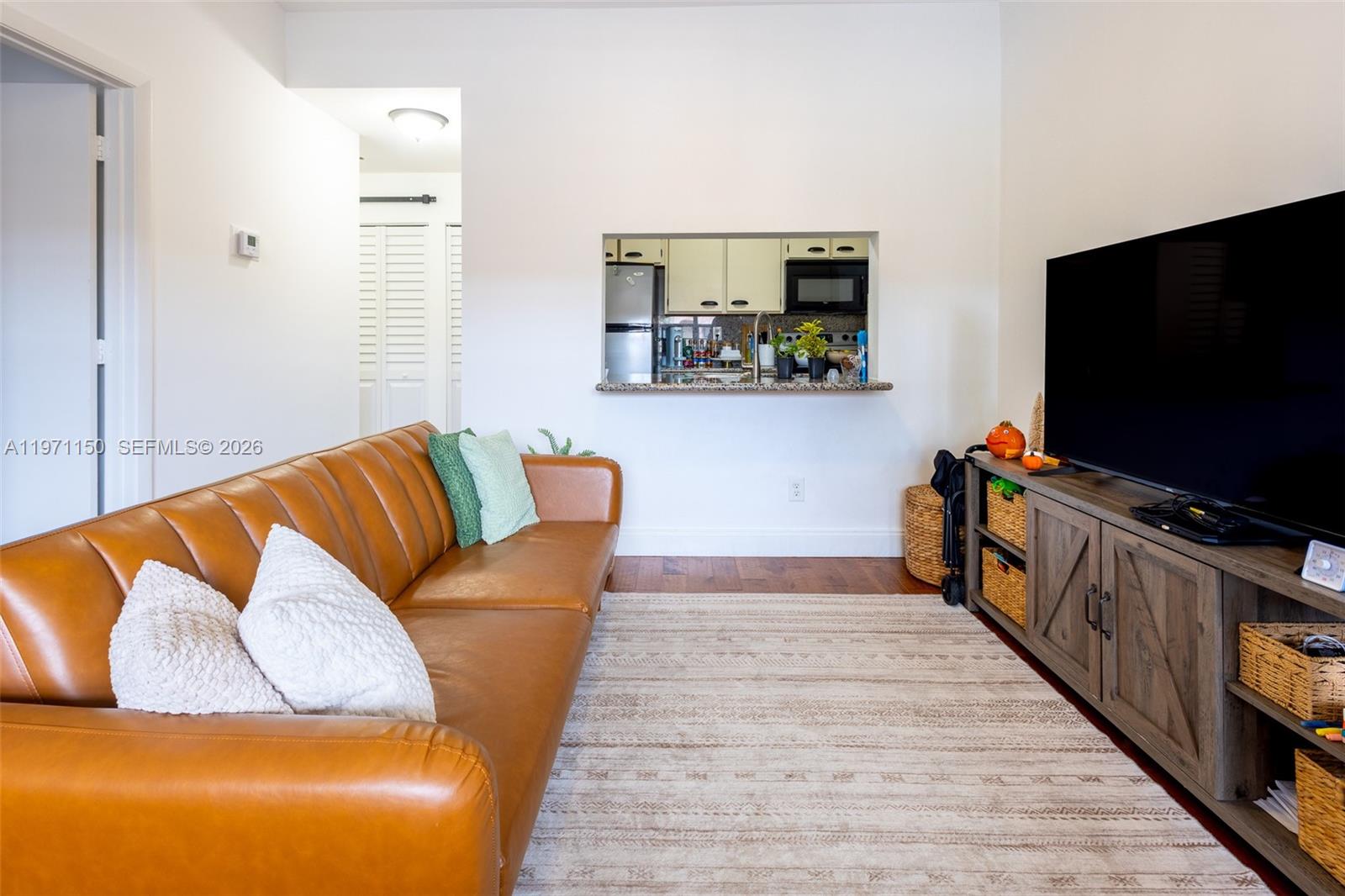 9430 Boca Cove Circle, Unit 210 Boca Raton, FL 33428 - Photo 4 of 24 a living room with furniture and a flat screen tv