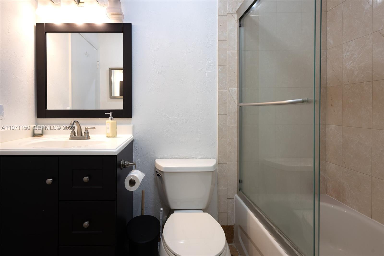 9430 Boca Cove Circle, Unit 210 Boca Raton, FL 33428 - Photo 9 of 24 a bathroom with a sink toilet and mirror