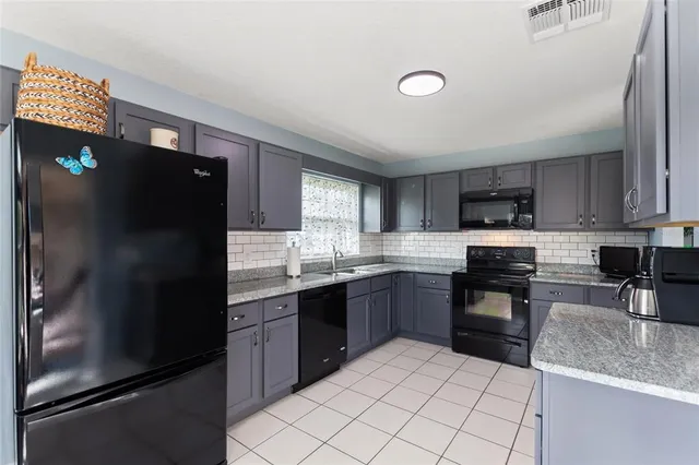 a kitchen with stainless steel appliances granite countertop a refrigerator sink and stove