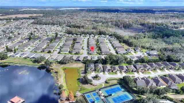 an aerial view of residential houses with outdoor space and parking