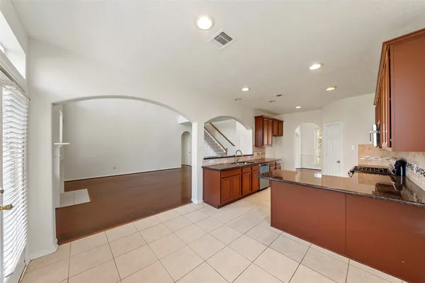 a kitchen with stainless steel appliances granite countertop a refrigerator and a sink