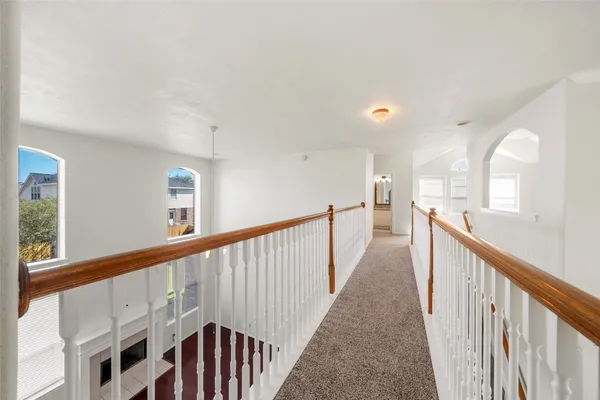 an empty room with windows and ceiling fan