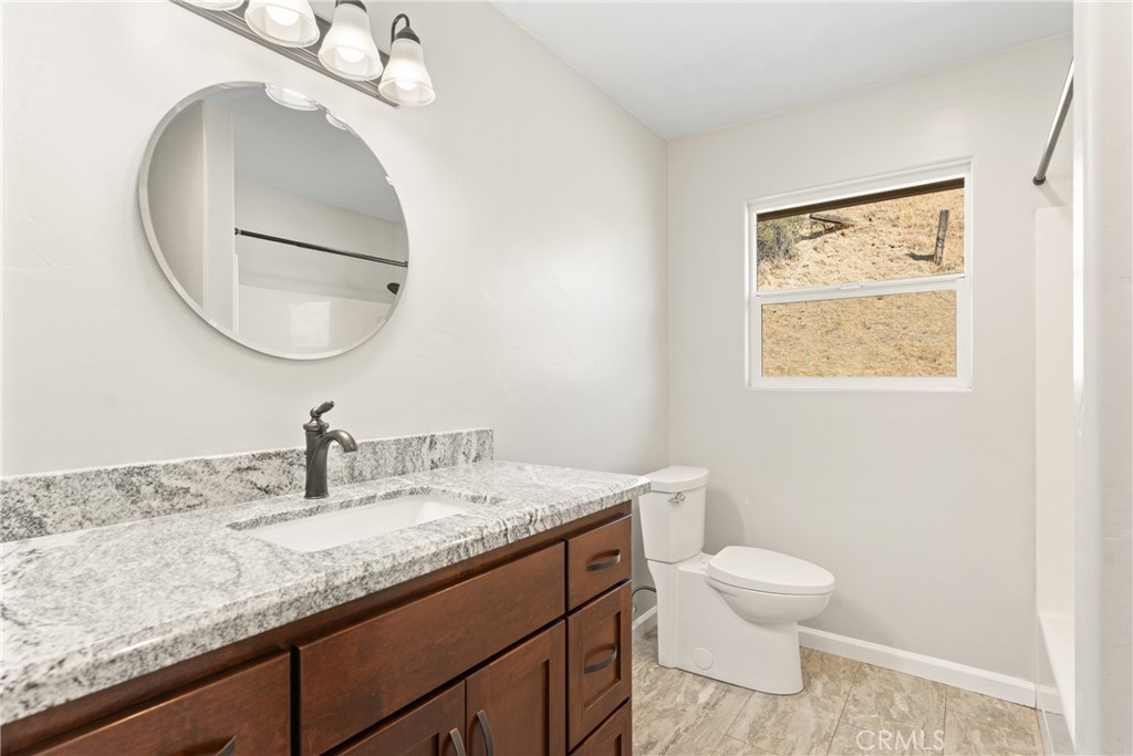 30300 Live Oak Canyon Road Redlands, CA 92373 - Photo 27 of 67 a bathroom with a granite countertop toilet sink and mirror