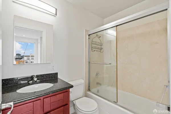 a bathroom with a granite countertop sink toilet and shower