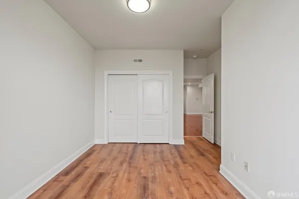 a view of a room with wooden floor and white walls