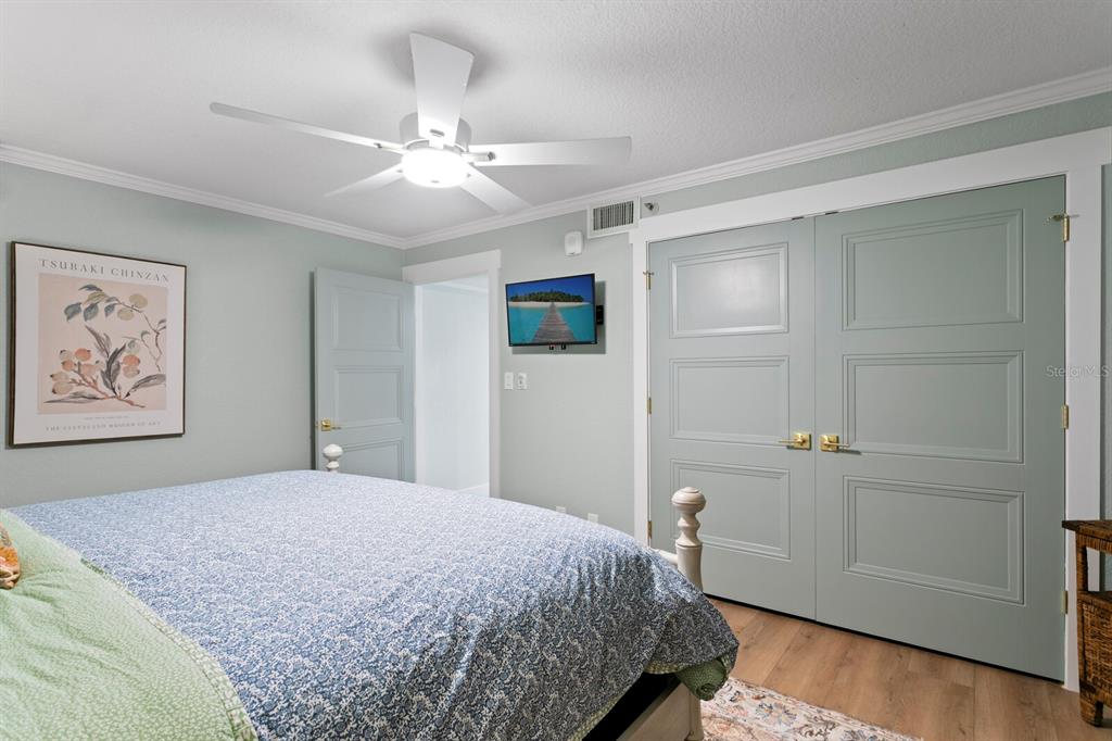 16332 Gulf Boulevard, Unit 3B Redington Beach, FL 33708 - Photo 36 of 93 a bedroom with a large bed and a chandelier