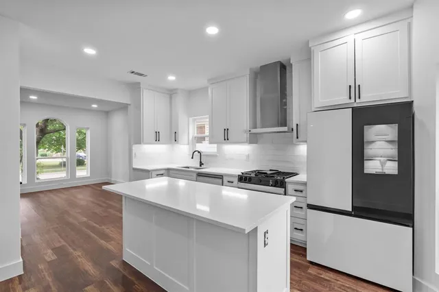 a kitchen with stainless steel appliances granite countertop a sink a stove and a refrigerator