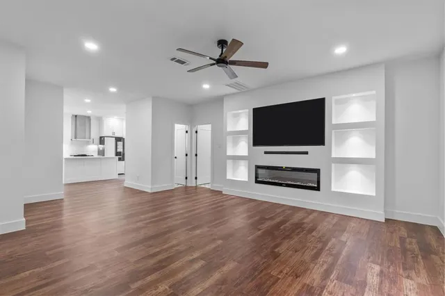 a view of a livingroom with wooden floor and a flat screen tv
