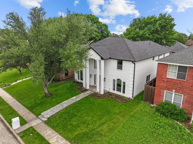 a front view of a house with a garden and yard