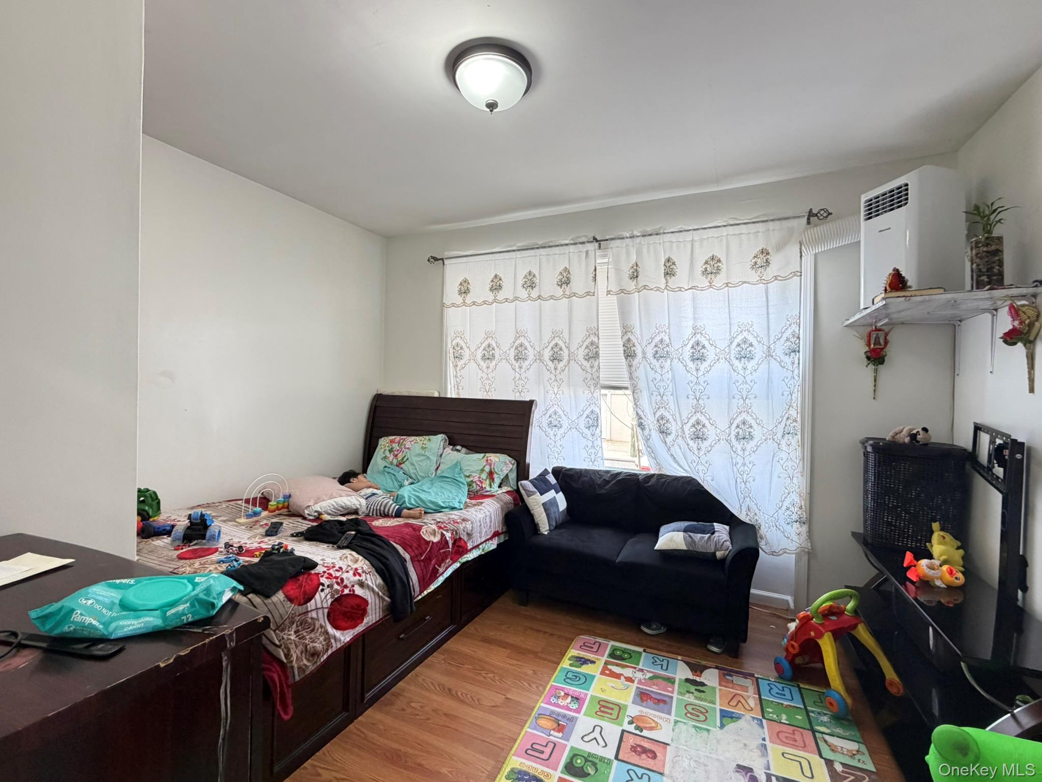 100-04 Spruce Street Queens, NY 11368 - Photo 7 of 12 a bedroom with bed and a window