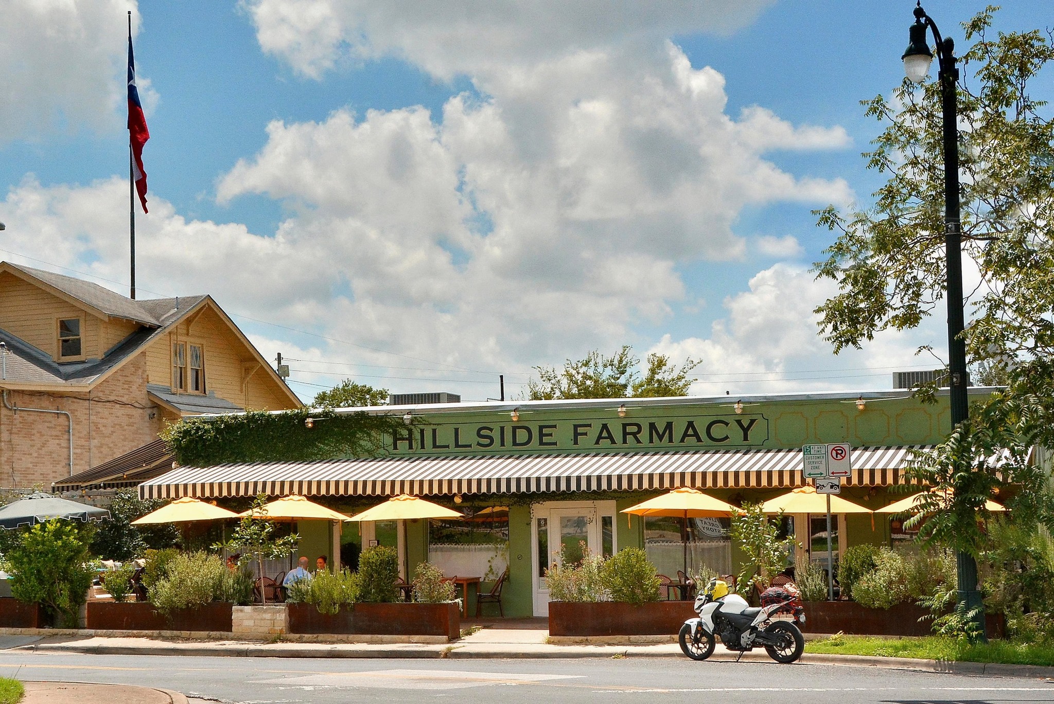 800 Embassy Drive, Unit 602 Austin, TX 78702 - Photo 31 of 37 Commercial building with a green facade, striped awnings, and outdoor patio seating