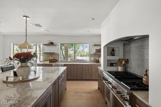 a kitchen with stainless steel appliances granite countertop a sink stove and refrigerator