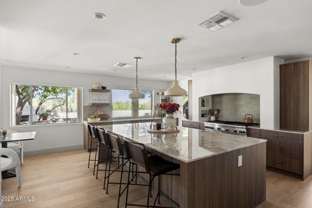 a kitchen with stainless steel appliances granite countertop a sink a stove and a refrigerator