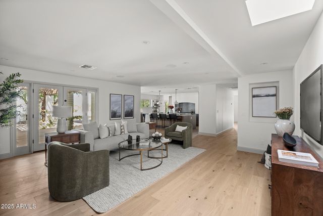 a living room with furniture a large window and gym equipment