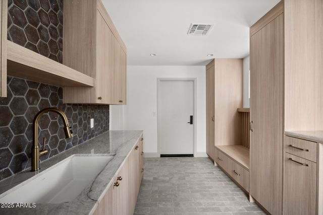 a kitchen with granite countertop a sink and a stove top oven