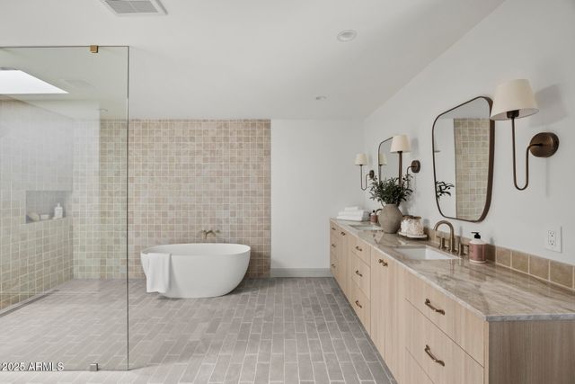 a spacious bathroom with a double vanity sink mirror and shower
