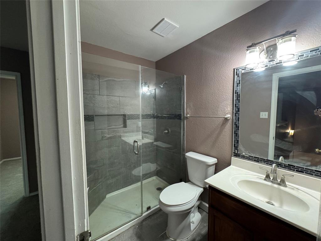 3200 Crownover Street Austin, TX 78725 - Photo 14 of 23 A well-appointed bathroom features a modern glass-enclosed shower and a vanity with ample counter space.