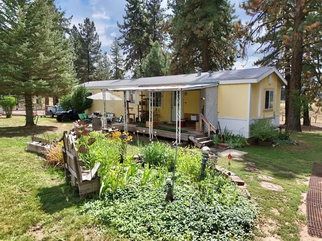 a view of a house with backyard sitting area and garden