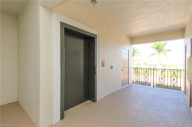 a view of a hallway with windows and chandelier
