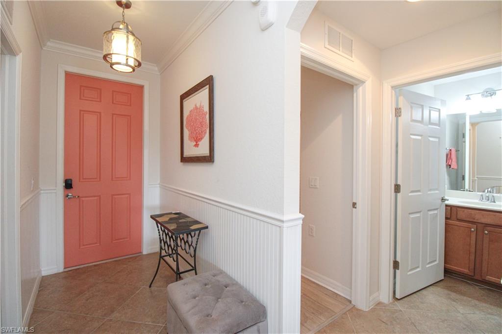 9554 Trevi Court, Unit 4737 Naples, FL 34113 - Photo 7 of 49 a view of a hallway with windows and chandelier