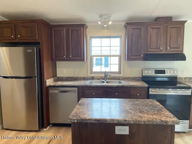 a kitchen with stainless steel appliances granite countertop a sink stove and refrigerator