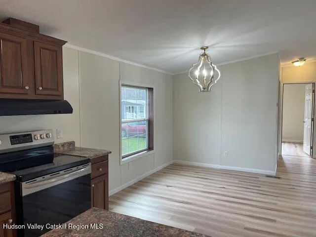 a kitchen with a stove and a wooden floor