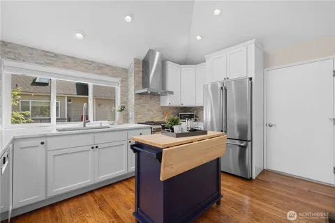 a kitchen with kitchen island granite countertop a sink stove and refrigerator
