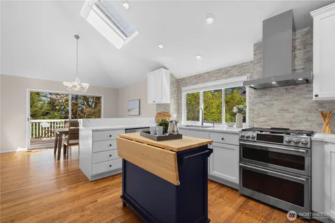 a kitchen with a stove a sink and chairs