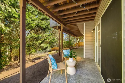 a outdoor room with a large window and chairs