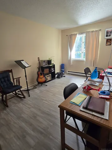 a view of a workspace with furniture and a window