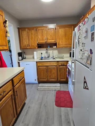 a kitchen with stainless steel appliances granite countertop wooden cabinets sink and a window
