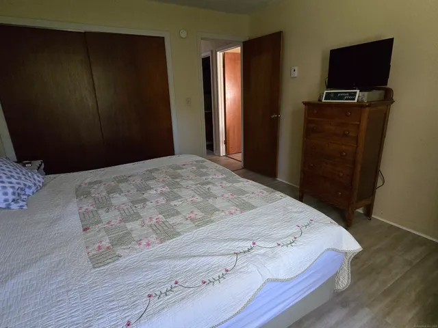 a bedroom with a bed and a tv on table