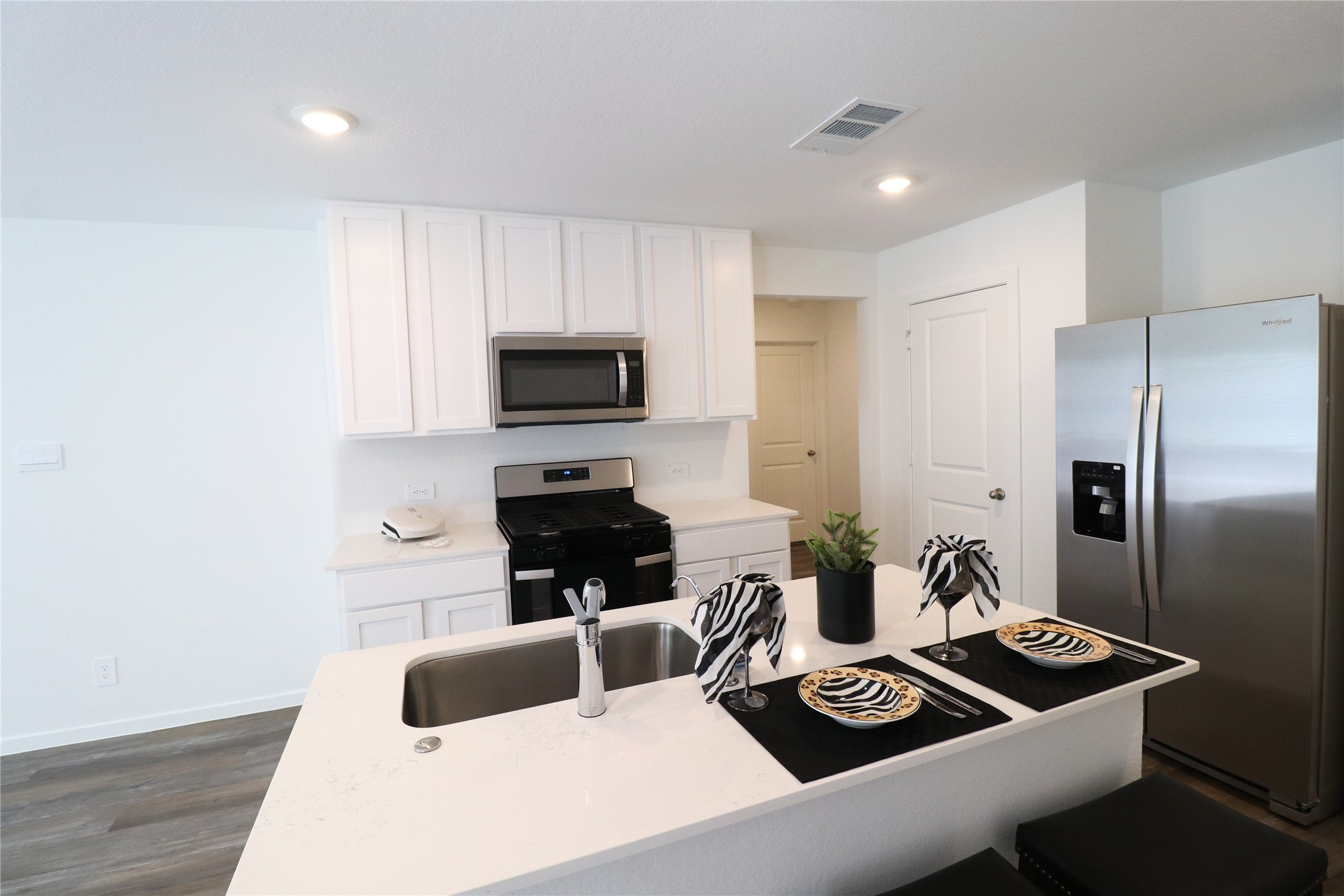 24134 Chirp Street Splendora, TX 77372 - Photo 2 of 14 a kitchen with a refrigerator and a stove top oven