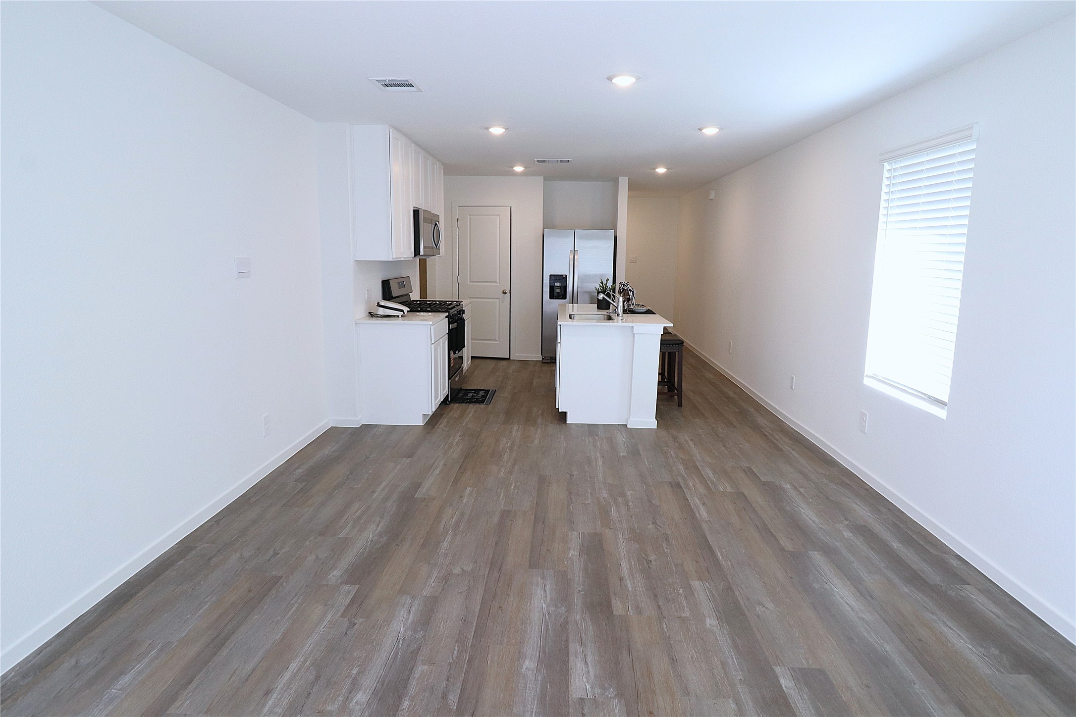 24134 Chirp Street Splendora, TX 77372 - Photo 5 of 14 a view of a kitchen with wooden floor and a window
