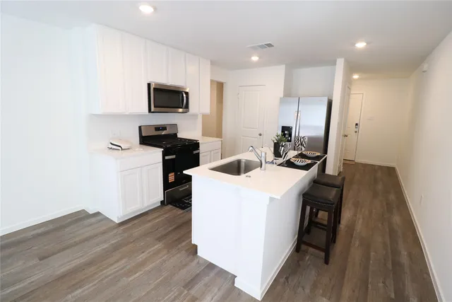 a kitchen with a sink a microwave a stove and refrigerator