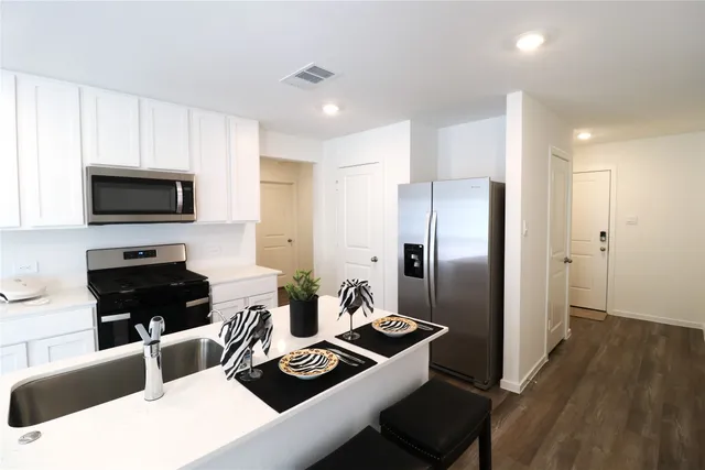 a kitchen with a refrigerator and a stove top oven