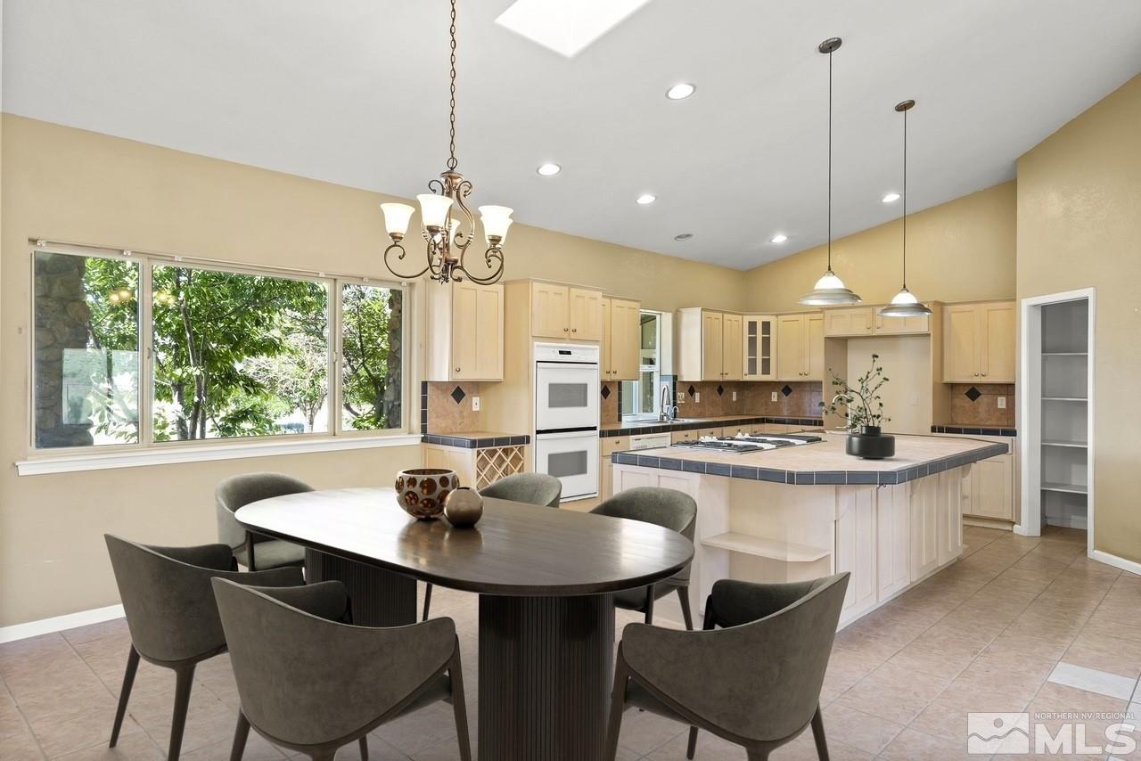 1683 Windmill Road Gardnerville, NV 89410 - Photo 27 of 40 a kitchen with kitchen island a dining table and chairs