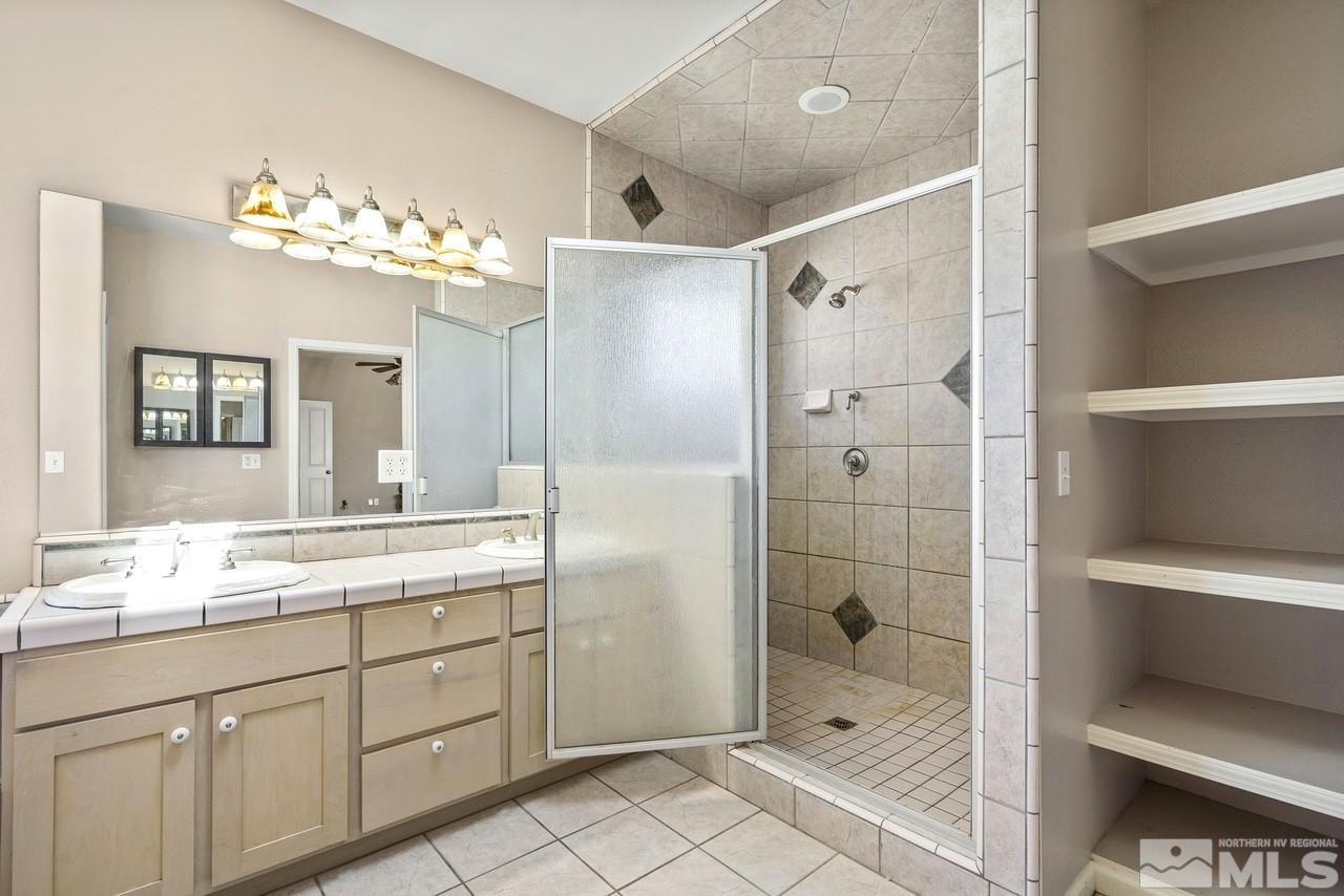 1683 Windmill Road Gardnerville, NV 89410 - Photo 28 of 40 a bathroom with a double vanity sink mirror and shower