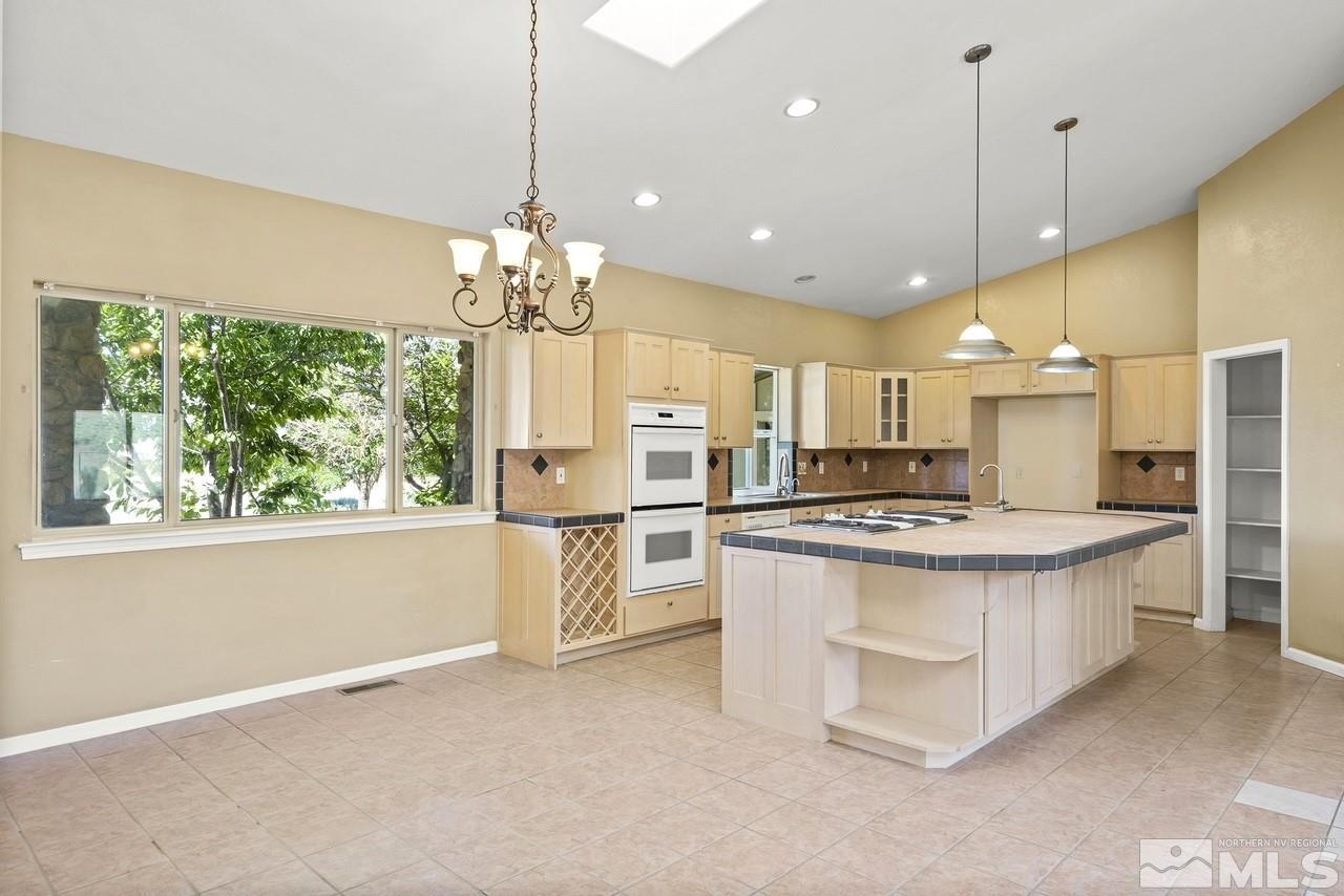 1683 Windmill Road Gardnerville, NV 89410 - Photo 37 of 40 a kitchen with stainless steel appliances granite countertop a stove oven and a refrigerator