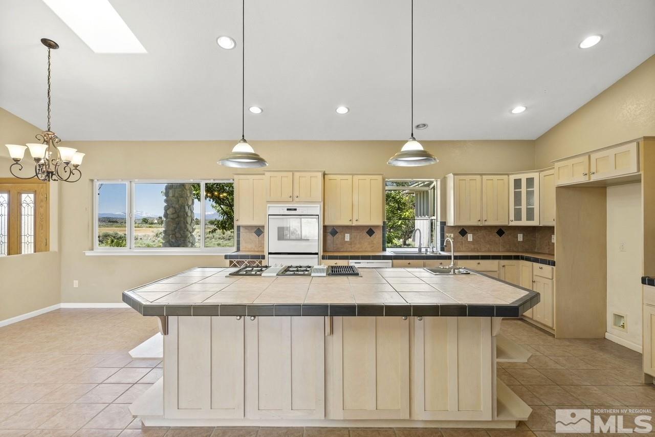 1683 Windmill Road Gardnerville, NV 89410 - Photo 39 of 40 a kitchen with stainless steel appliances granite countertop a stove a refrigerator a sink a center island a table and chairs