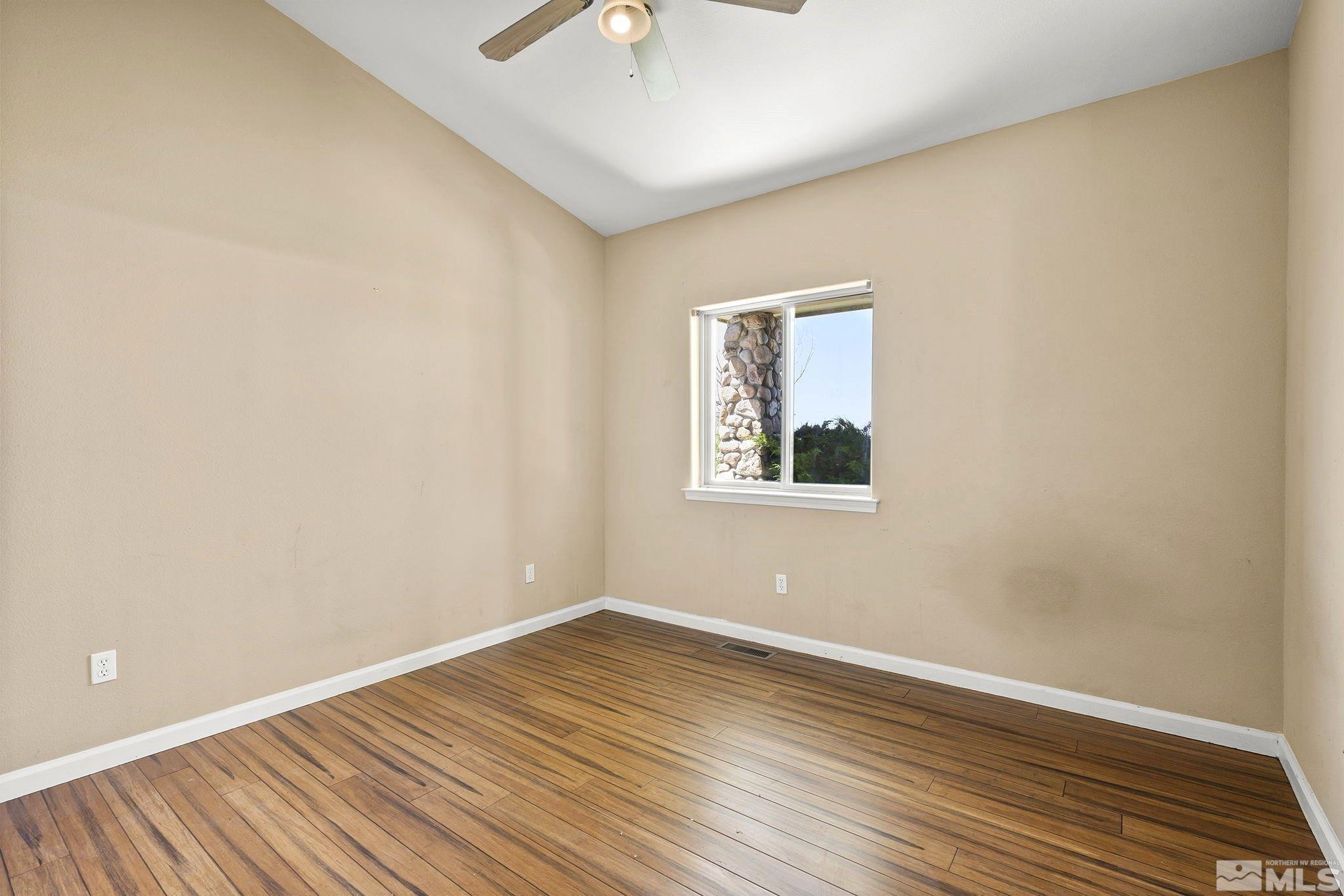 1683 Windmill Road Gardnerville, NV 89410 - Photo 6 of 40 an empty room with wooden floor and windows