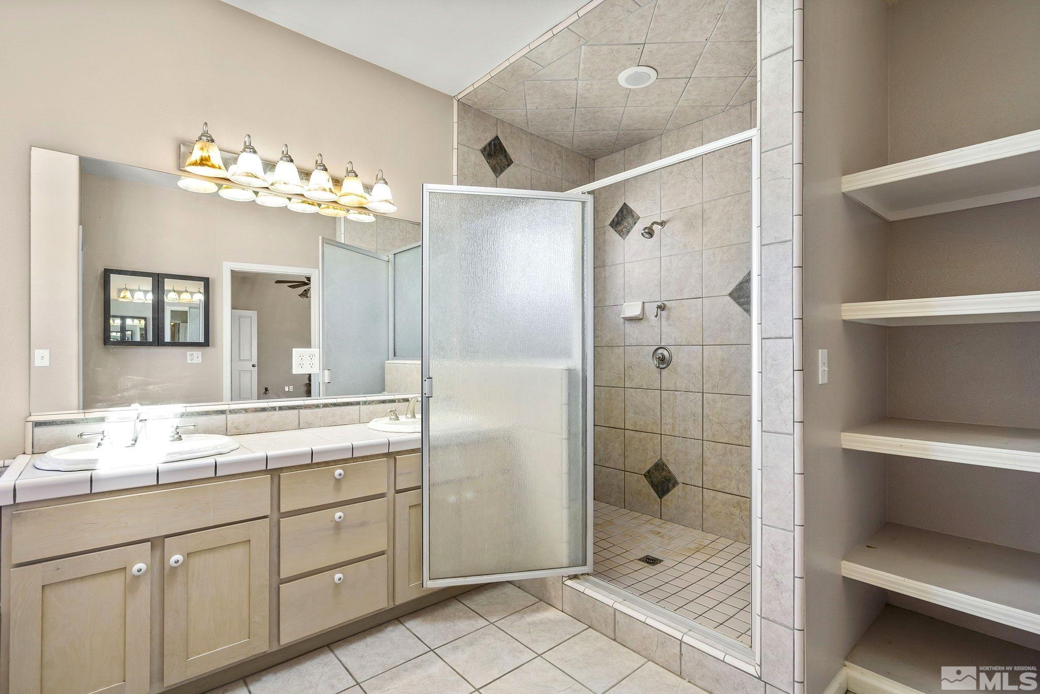 1683 Windmill Road Gardnerville, NV 89410 - Photo 10 of 40 a bathroom with a double vanity sink mirror and shower