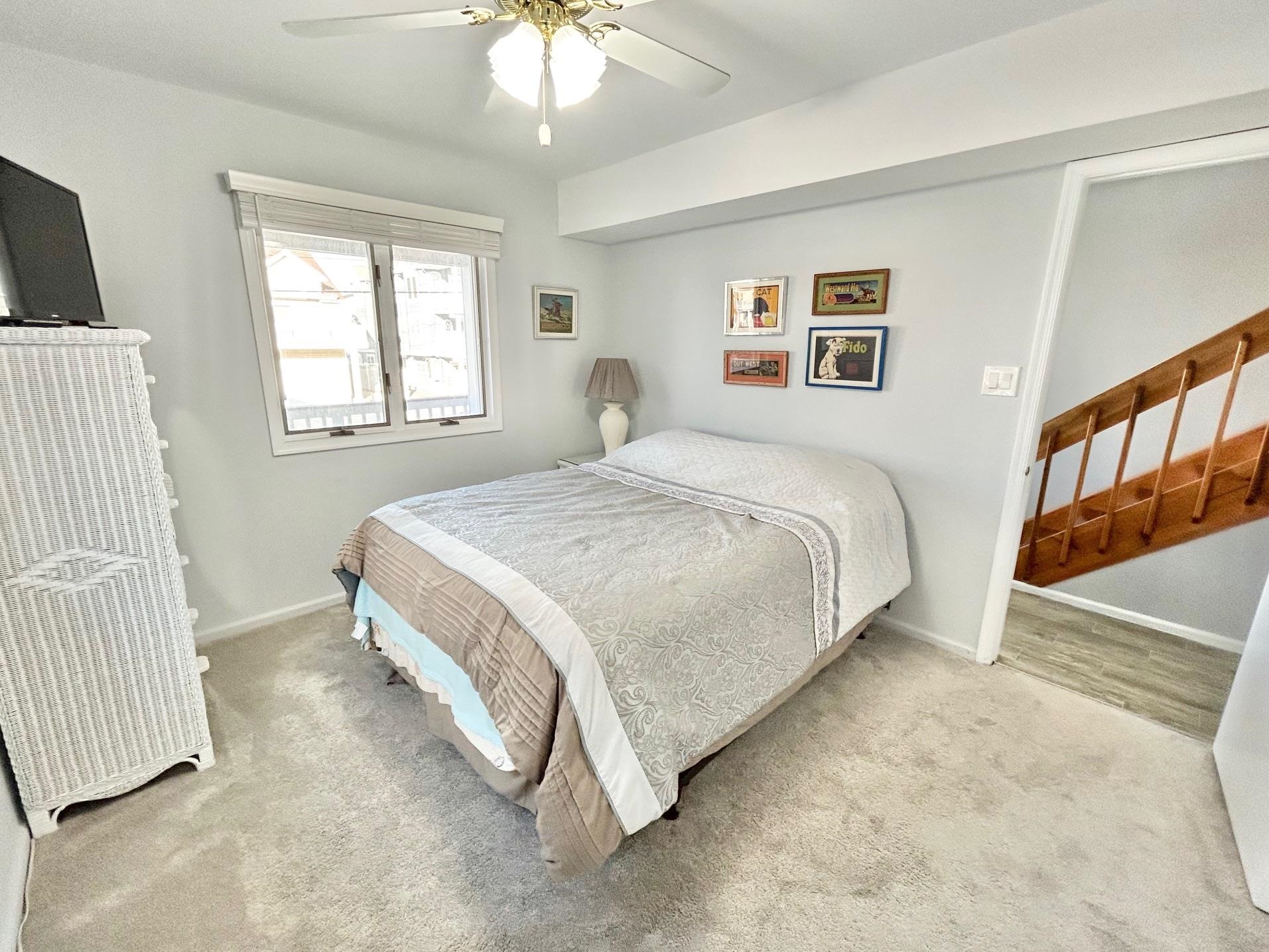 26 73rd Street, Unit WEST Sea Isle City, NJ 08243 - Photo 12 of 21 a spacious bedroom with a bed and a window
