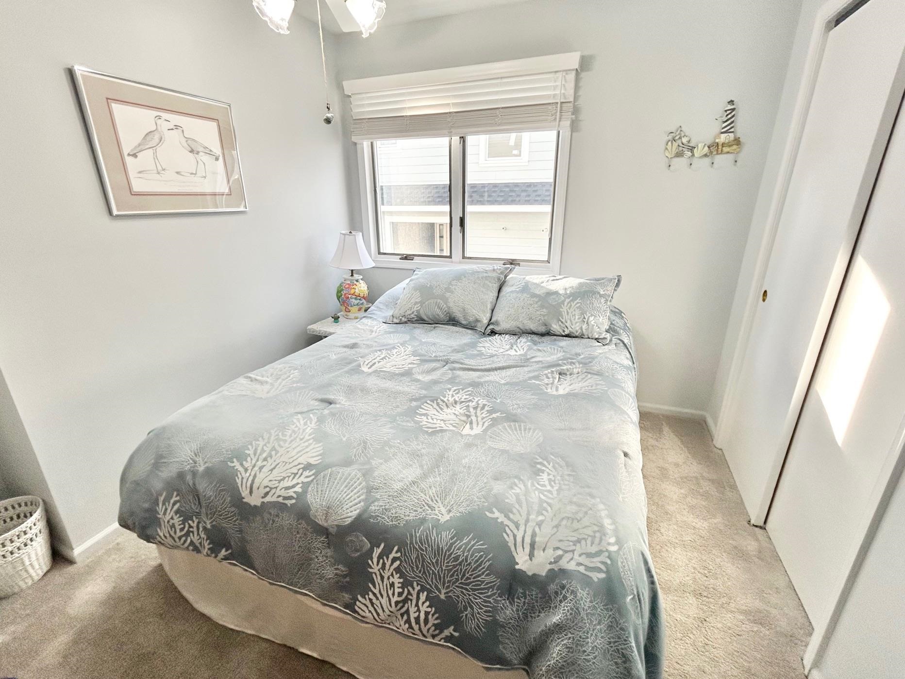 26 73rd Street, Unit WEST Sea Isle City, NJ 08243 - Photo 13 of 21 a large bed sitting in a bedroom next to a window