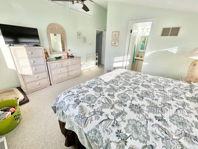 a bedroom with a bed and a flat tv screen on dresser