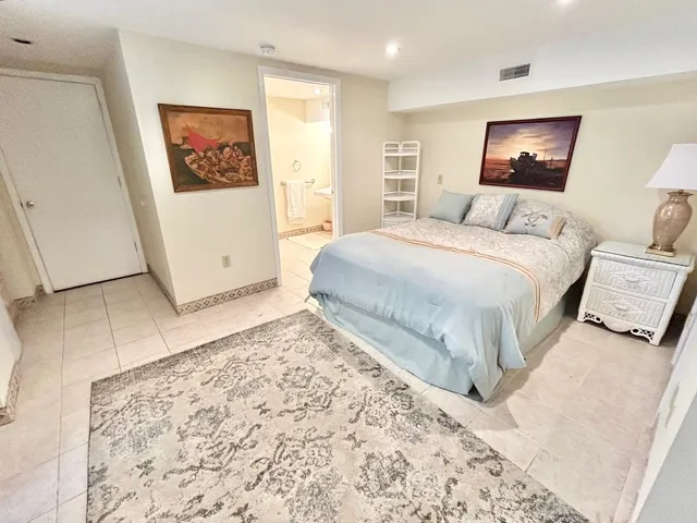 a bedroom with a bed and a refrigerator