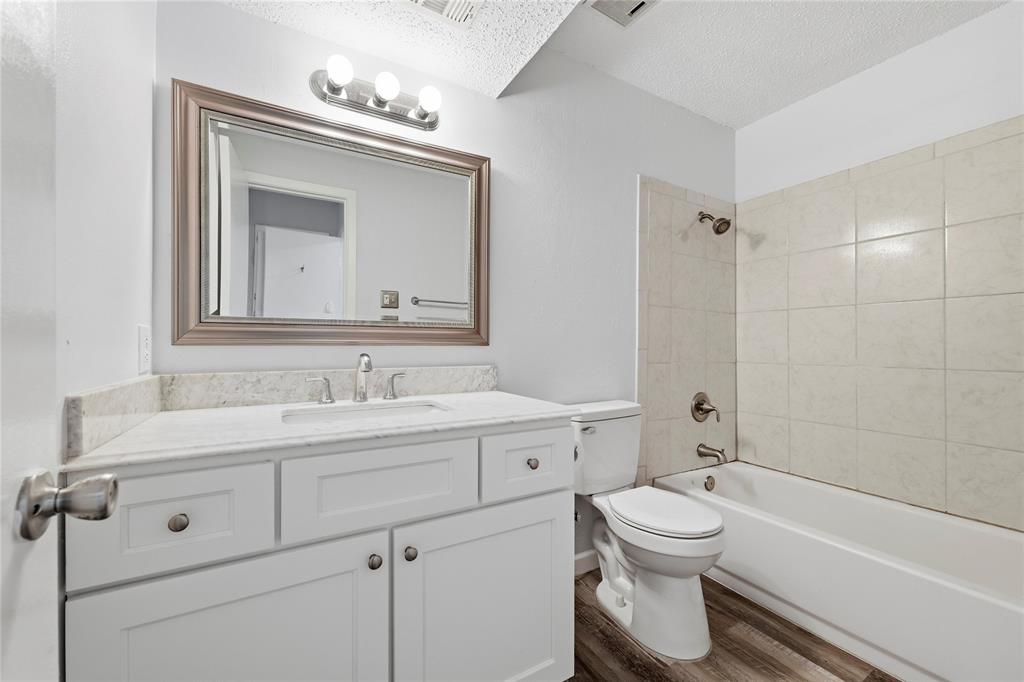 12482 Abrams Road, Unit 1327 Dallas, TX 75243 - Photo 19 of 32 a bathroom with a toilet sink a mirror and bathtub